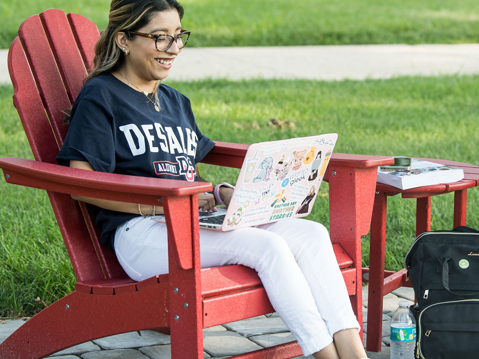 student outdoors with laptop