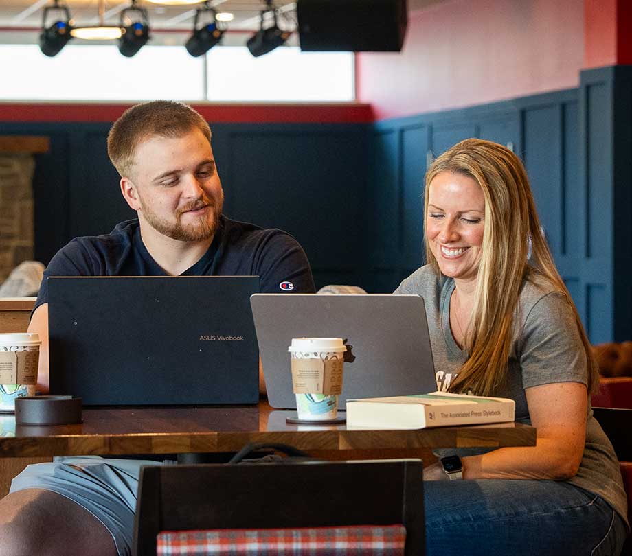 students at cafe with laptops