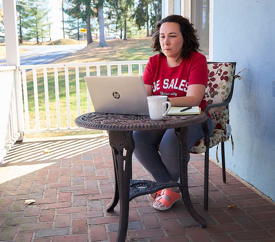 woman sitting on porch with laptop