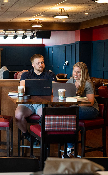 students with laptops at cafe