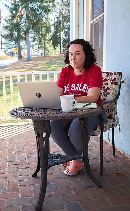 woman sitting on porch with laptop