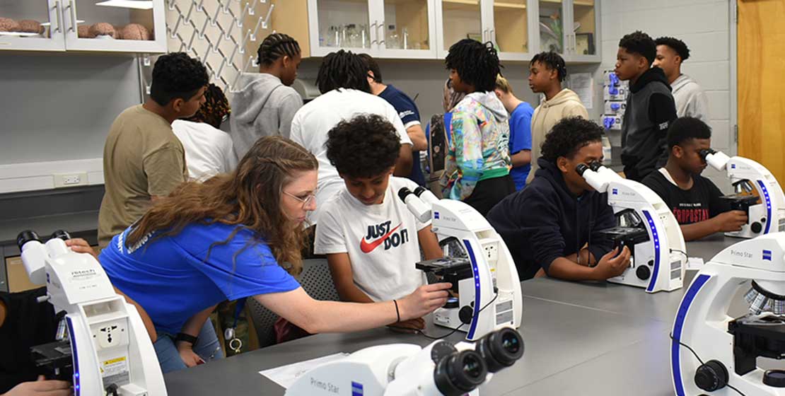 students learning how to use microscopes in the classroom